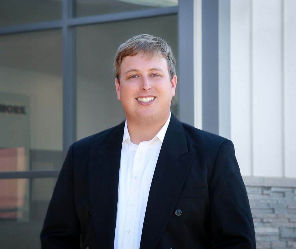 Man in front of an office smiling
