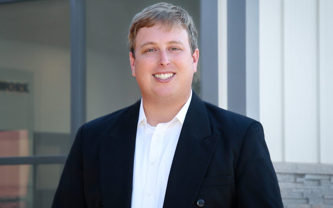 Man in front of an office smiling
